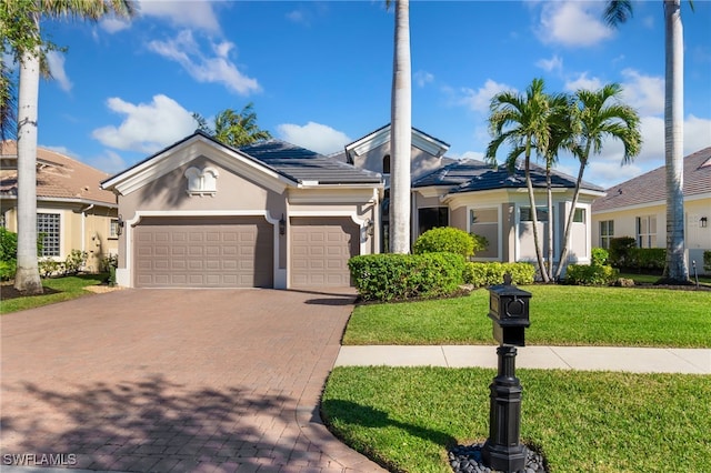 ranch-style home featuring a front lawn and a garage