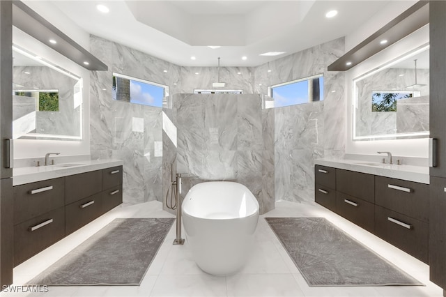 bathroom featuring plus walk in shower, tile walls, and vanity