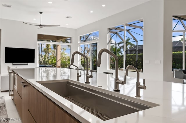 kitchen featuring ceiling fan and sink