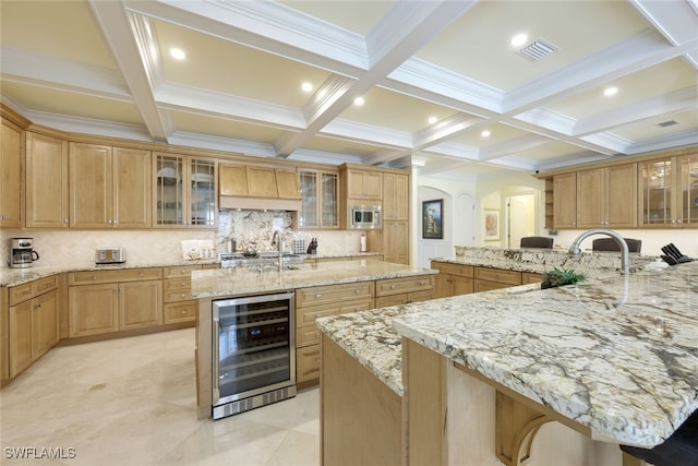 kitchen with beverage cooler, glass insert cabinets, and a large island with sink