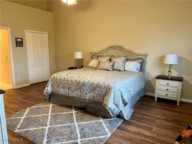 bedroom with dark hardwood / wood-style floors and a closet