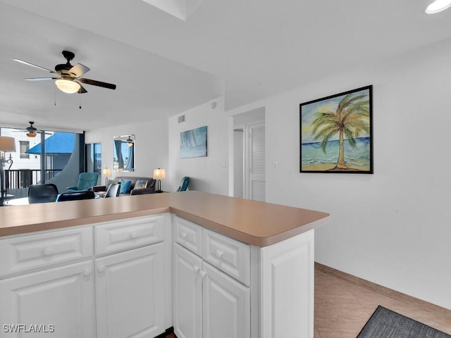 kitchen featuring white cabinets, kitchen peninsula, ceiling fan, and light tile patterned flooring