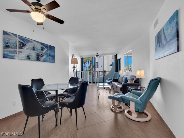 tiled dining area featuring ceiling fan and floor to ceiling windows