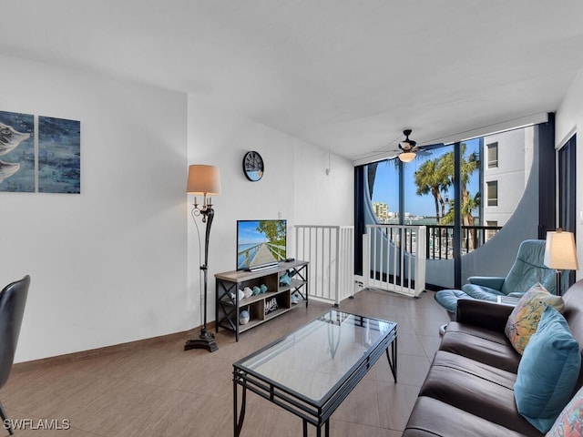 living room featuring ceiling fan and a wall of windows