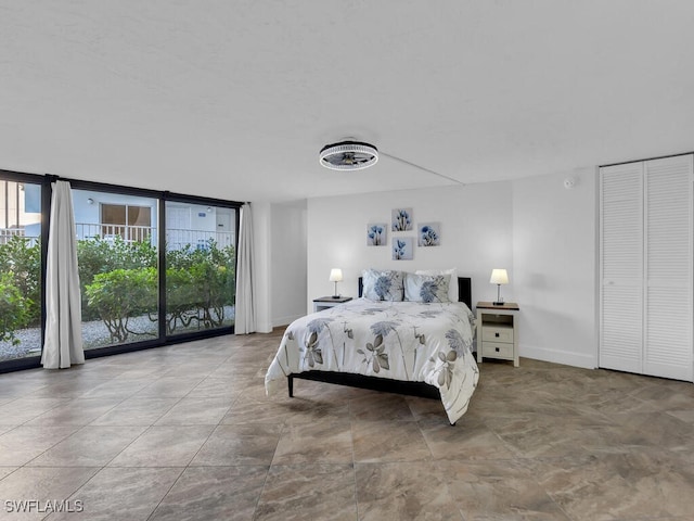 bedroom featuring access to outside and a wall of windows