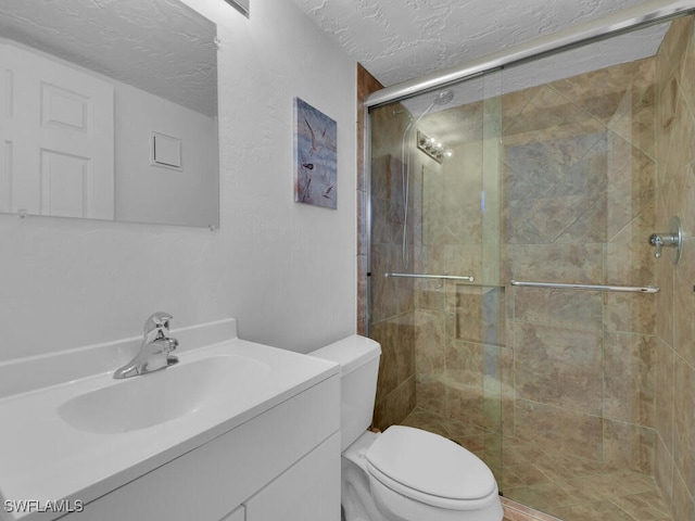 bathroom featuring vanity, a textured ceiling, toilet, and an enclosed shower