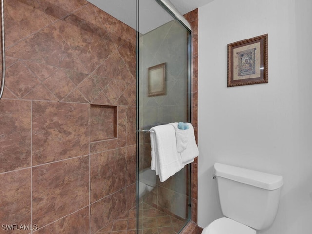 bathroom with an enclosed shower and toilet