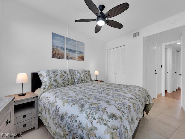 tiled bedroom with ceiling fan and a closet