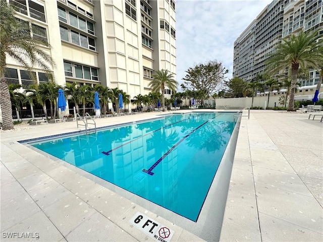 community pool featuring fence and a patio area