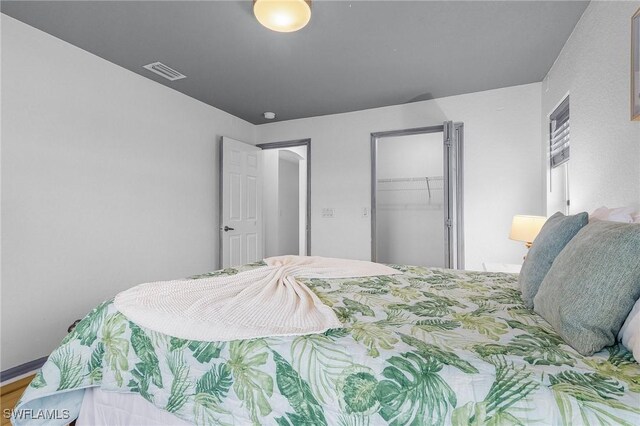 bedroom featuring visible vents, a walk in closet, and a closet