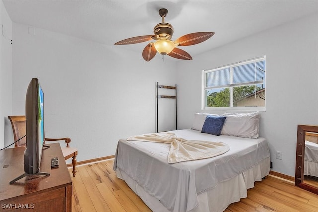 bedroom featuring baseboards, ceiling fan, and light wood-style floors