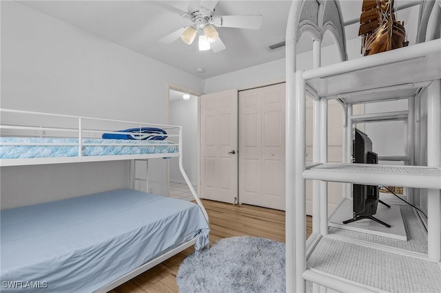 bedroom featuring ceiling fan, a closet, and hardwood / wood-style flooring