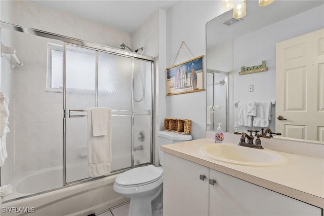 bathroom with visible vents, bath / shower combo with glass door, toilet, tile patterned flooring, and vanity