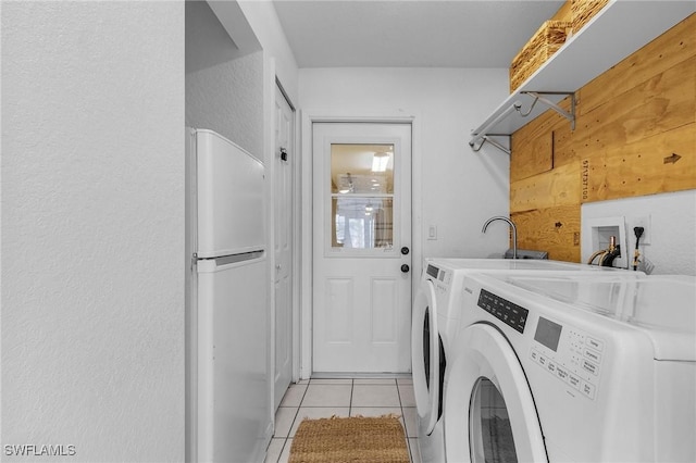 laundry area with light tile patterned floors, washing machine and dryer, and laundry area