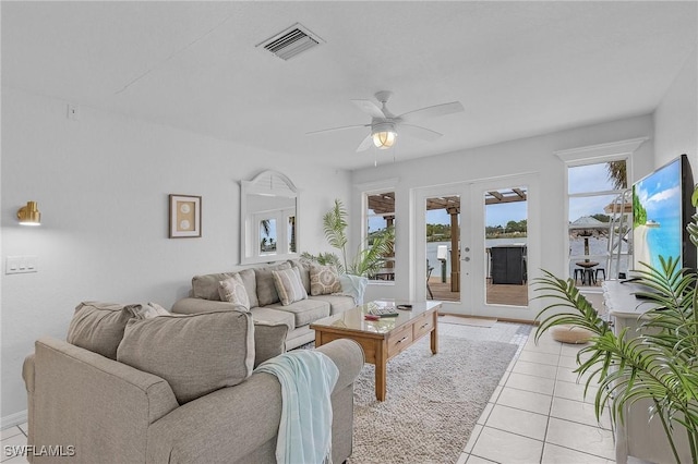 living area with light tile patterned floors, french doors, visible vents, and a ceiling fan