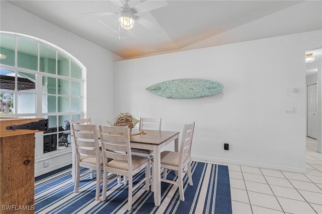 tiled dining space featuring vaulted ceiling, ceiling fan, and baseboards