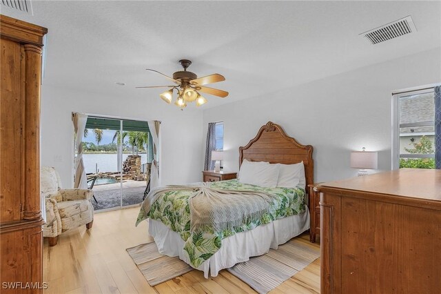 bedroom featuring access to exterior, light hardwood / wood-style floors, and ceiling fan