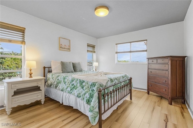 bedroom featuring light wood-style floors and multiple windows