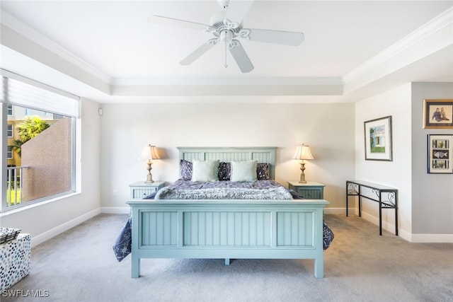 carpeted bedroom featuring ceiling fan, a raised ceiling, and crown molding