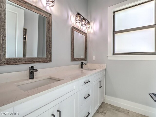 19871 Adams Rd, Fort Myers, FL 33908 - bathroom with a sink, baseboards, and double vanity