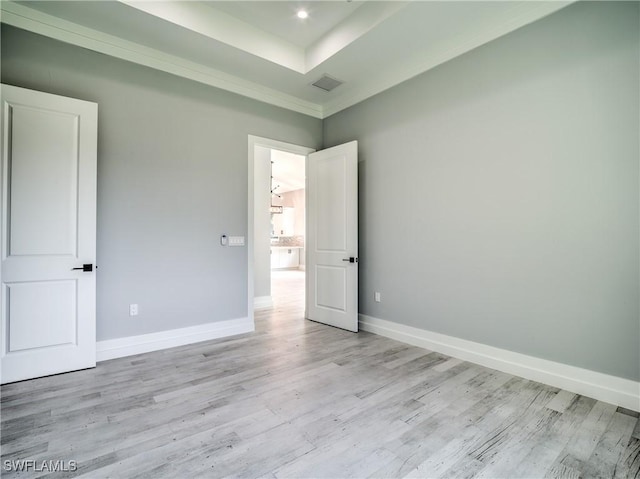 19871 Adams Rd, Fort Myers, FL 33908 - unfurnished bedroom featuring a tray ceiling, light wood-type flooring, baseboards, and visible vents