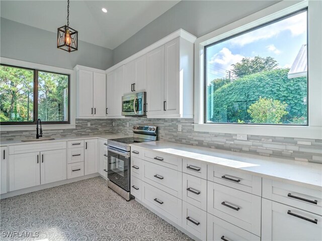 19871 Adams Rd, Fort Myers, FL 33908 - kitchen with tasteful backsplash, hanging light fixtures, a sink, white cabinetry, and stainless steel appliances