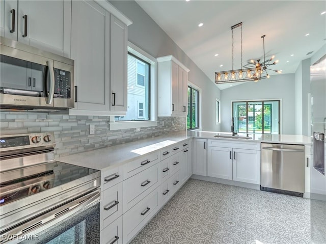 kitchen featuring white cabinets, sink, kitchen peninsula, and stainless steel appliances