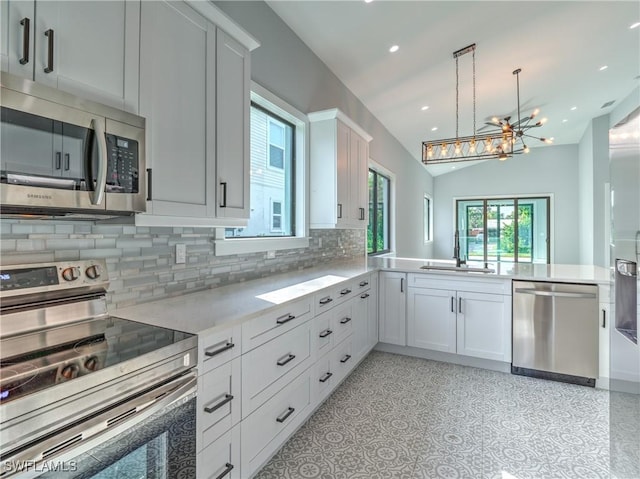 19871 Adams Rd, Fort Myers, FL 33908 - kitchen featuring a peninsula, vaulted ceiling, light countertops, a sink, and stainless steel appliances