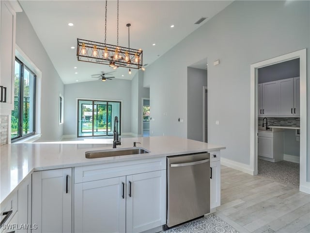 kitchen featuring lofted ceiling, white cabinets, sink, stainless steel dishwasher, and ceiling fan