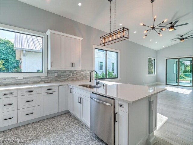 kitchen with sink, white cabinets, stainless steel dishwasher, and lofted ceiling