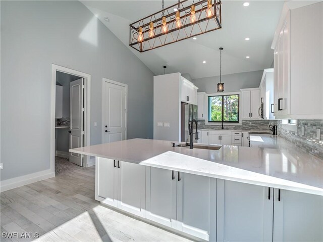19871 Adams Rd, Fort Myers, FL 33908 - kitchen featuring light wood-style flooring, white cabinets, a sink, decorative light fixtures, and decorative backsplash