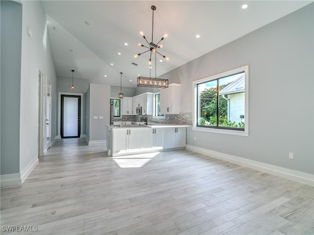 kitchen featuring light hardwood / wood-style flooring, white cabinetry, sink, and a chandelier