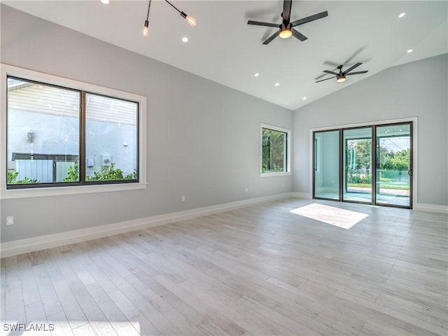 spare room featuring light hardwood / wood-style floors, vaulted ceiling, and ceiling fan