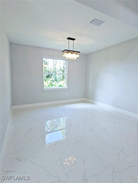 empty room featuring a chandelier