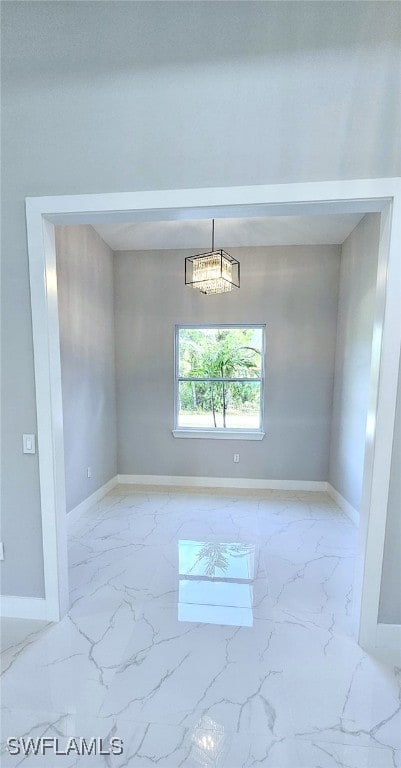 spare room featuring an inviting chandelier