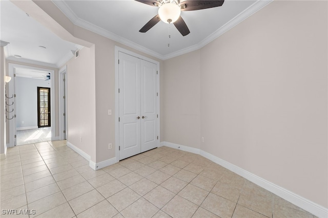 tiled empty room with crown molding and ceiling fan