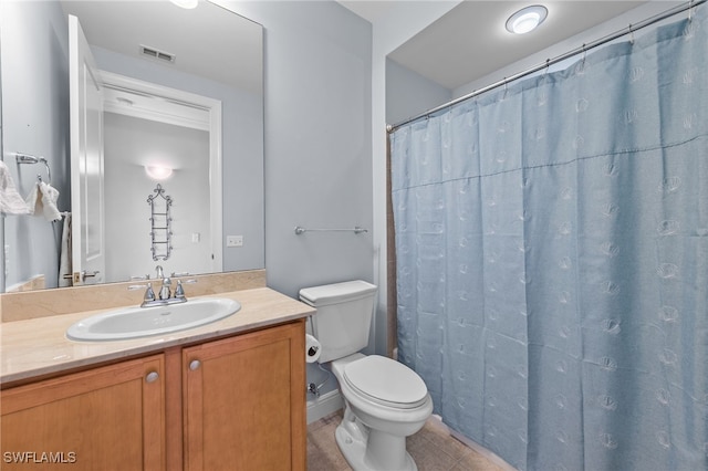 bathroom with vanity, toilet, tile patterned floors, and walk in shower