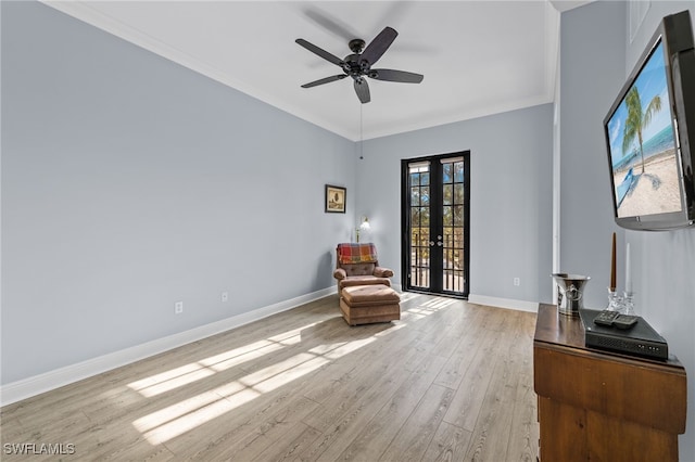 living area with light wood finished floors, french doors, a ceiling fan, baseboards, and ornamental molding