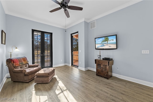 living area with ceiling fan, french doors, crown molding, and hardwood / wood-style flooring