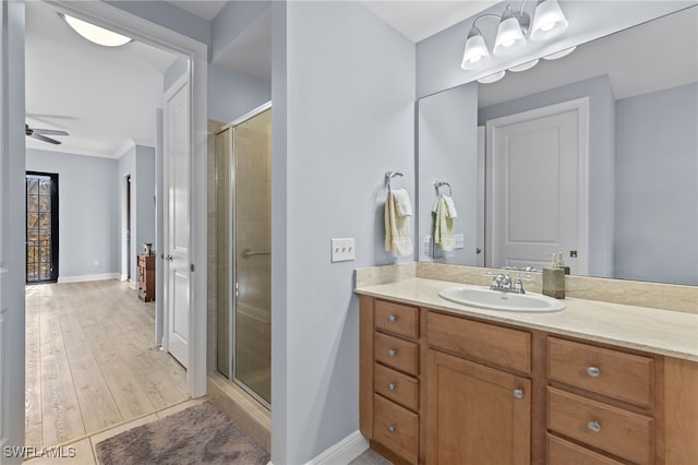 bathroom with hardwood / wood-style floors, ceiling fan, vanity, and walk in shower