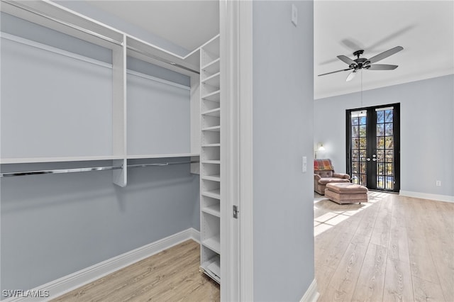 spacious closet featuring french doors, hardwood / wood-style floors, and ceiling fan