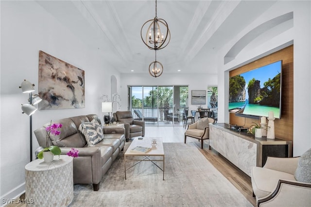 living room featuring a notable chandelier, light wood-type flooring, and ornamental molding