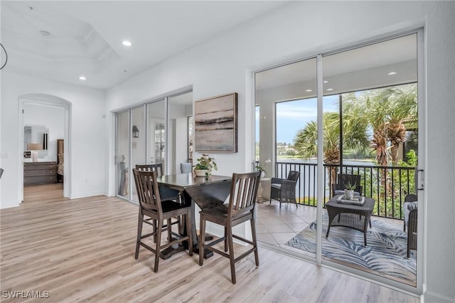 dining area featuring a tray ceiling and light hardwood / wood-style flooring