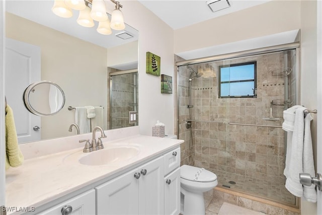 bathroom featuring tile patterned flooring, vanity, toilet, and a shower with door