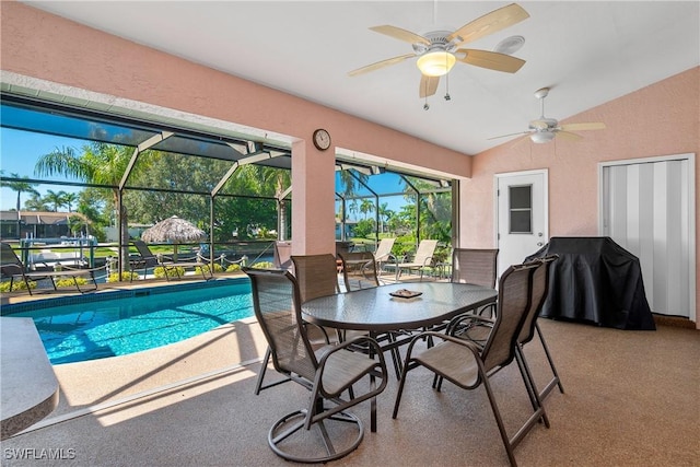 view of pool featuring glass enclosure, ceiling fan, a patio area, and grilling area