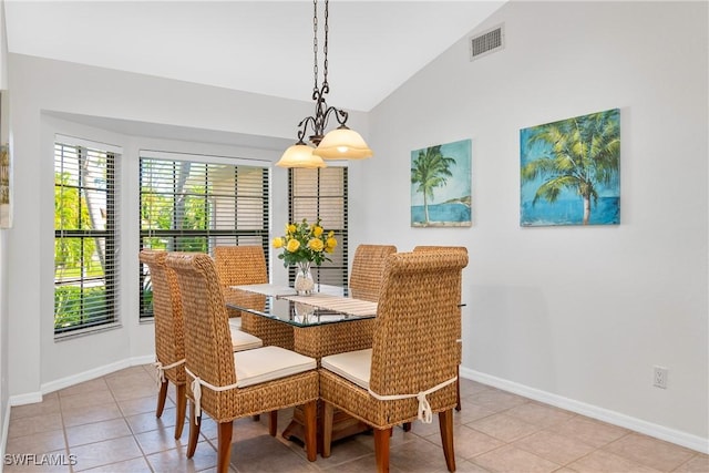 tiled dining room featuring lofted ceiling