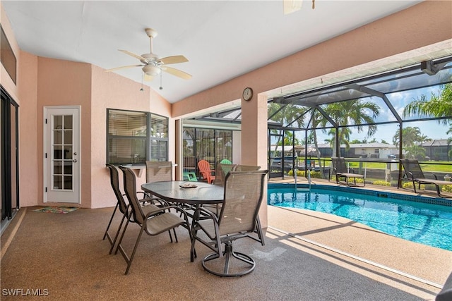 view of swimming pool featuring ceiling fan, a patio area, and glass enclosure