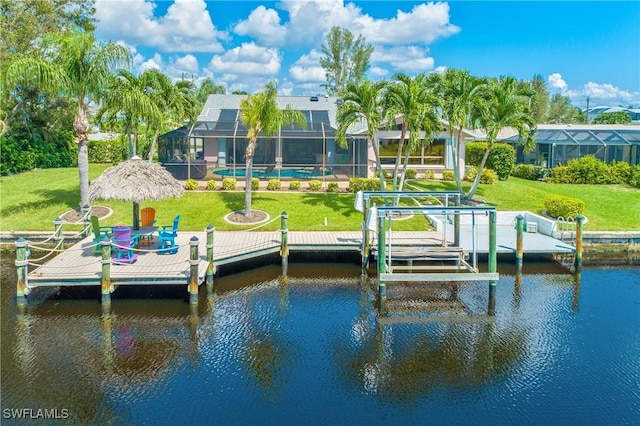 view of dock with a lawn, glass enclosure, and a water view