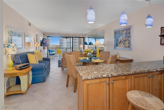 kitchen with pendant lighting, stone countertops, and light tile patterned floors