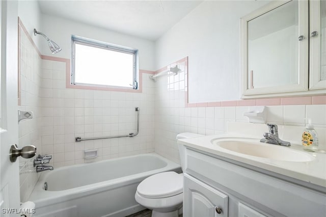 full bathroom with vanity, toilet, tile walls, and tiled shower / bath